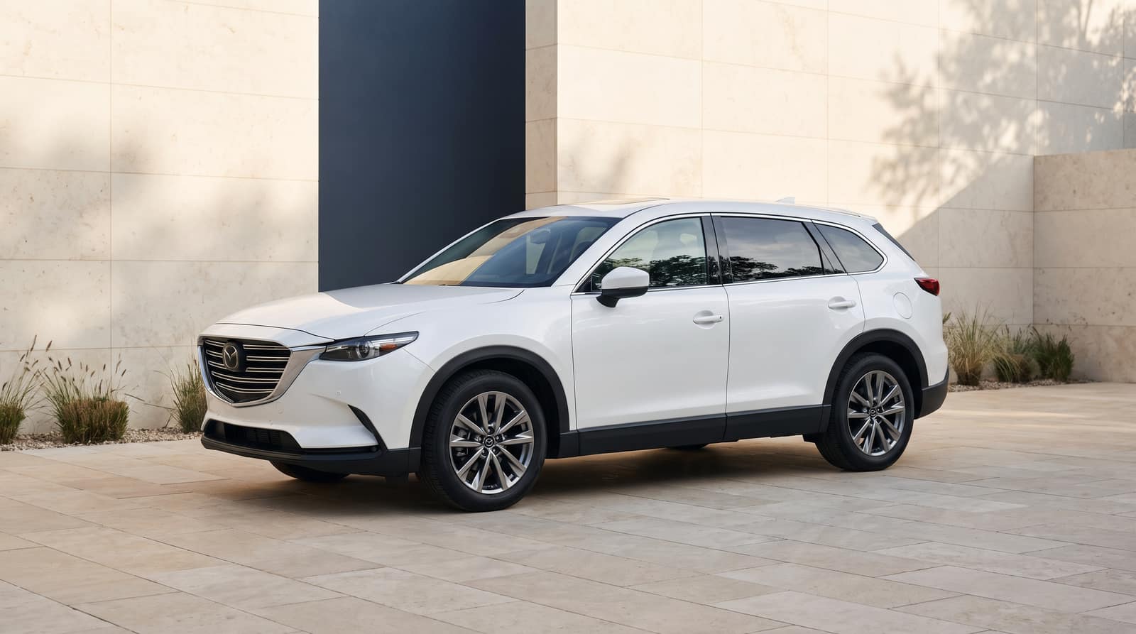 White 2021 Mazda CX-9, front three-quarter view in an architectural courtyard