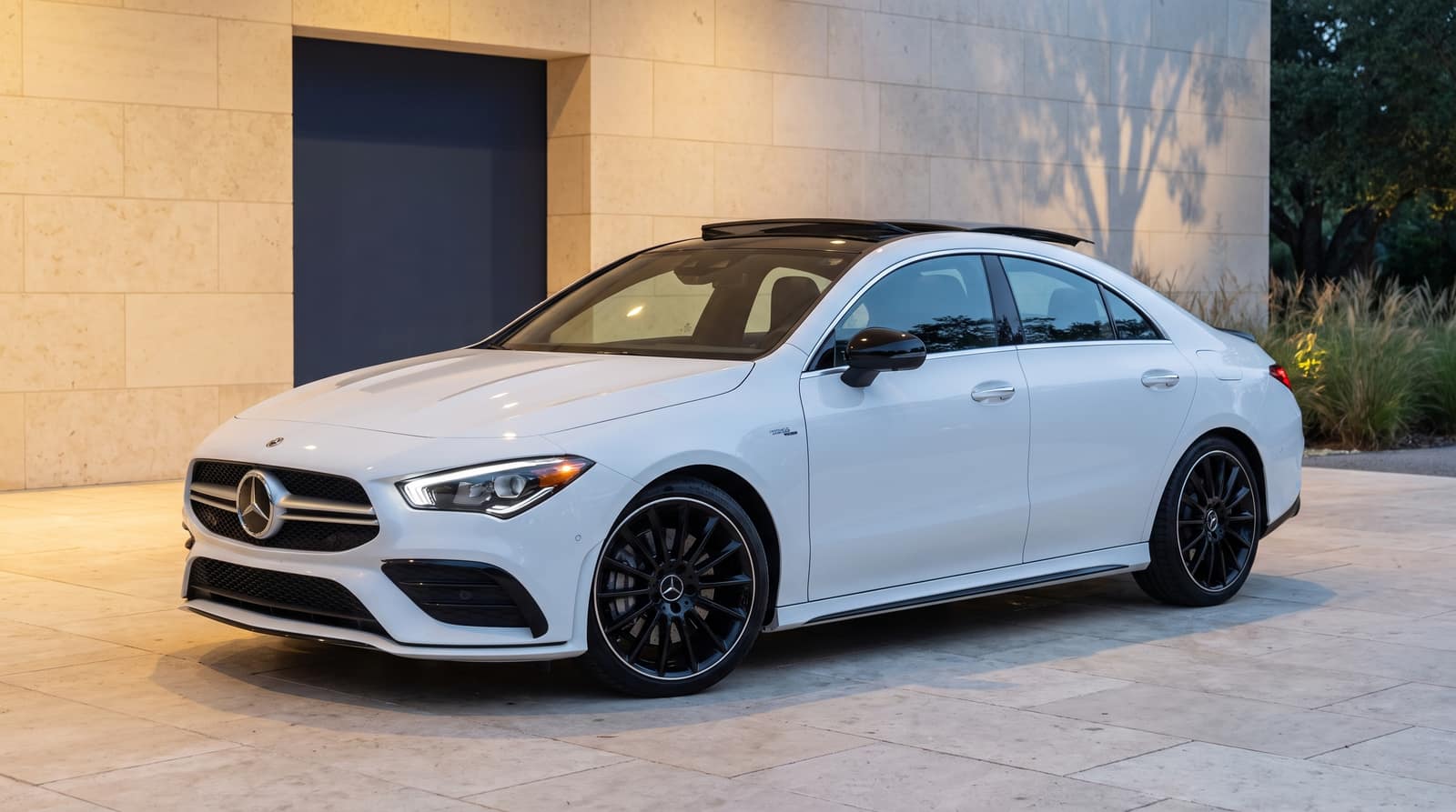 White 2022 Mercedes-AMG CLA 35, front three-quarter view in an architectural courtyard