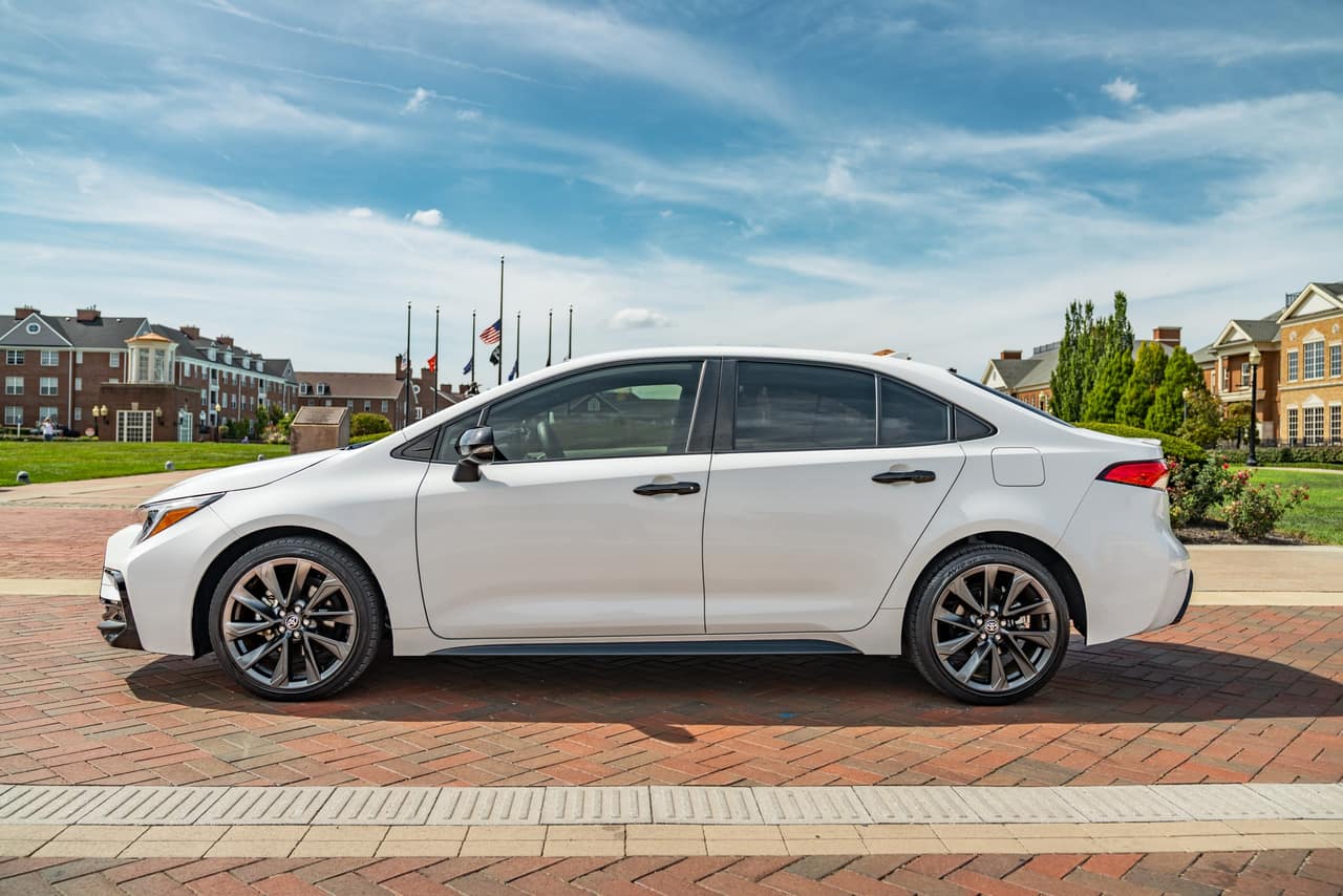 Side profile of the white Toyota Corolla Hybrid SE with black wheels