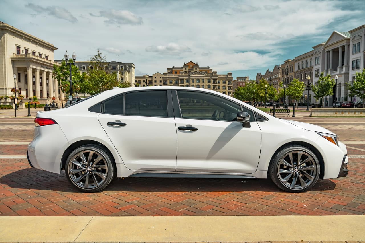 Opposite side profile of the white Toyota Corolla Hybrid SE