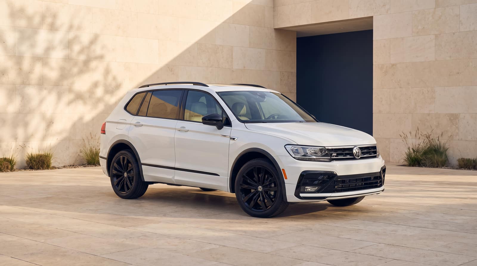 White 2021 Volkswagen Tiguan, front three-quarter view in an architectural courtyard